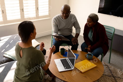 Preview: African american senior couple having meeting with asian female financial advisor at home