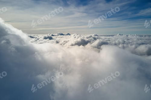Preview: Aerial view from airplane window at high altitude of earth covered with puffy cumulus clouds