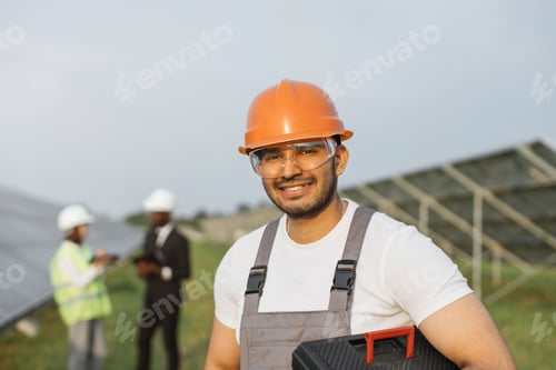 Preview: Indian man in uniform smiling on camera at solar station