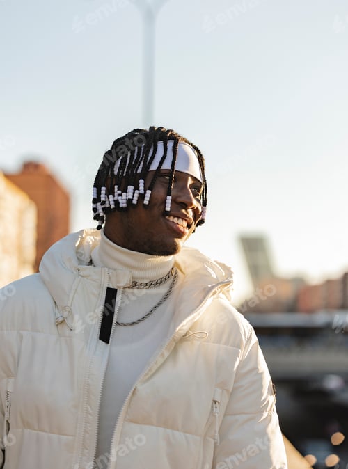 Preview: Confident handsome african man standing in the city looking around. young guy with dreadlocks.