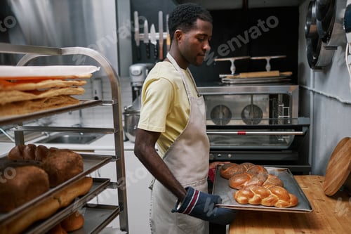 Preview: Baker Putting Tray with Bread on Table