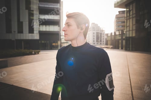 Preview: Young male runner preparing for run in city square