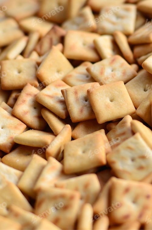 Preview: A lot of small cookies are square shaped. A pattern of a yellow salt cracker
