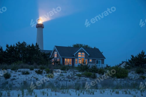 Preview: Lighthouse beaming near beach house