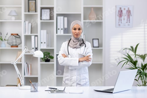 Preview: Portrait of serious confident successful female doctor in hijab in white medical coat looking at