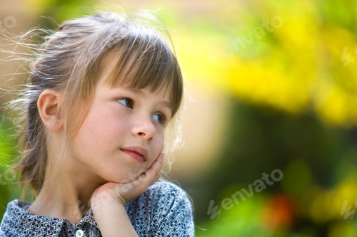 Preview: Portrait of cute pretty thoughtful child girl outdoors on blurred sunny colorful bright background.