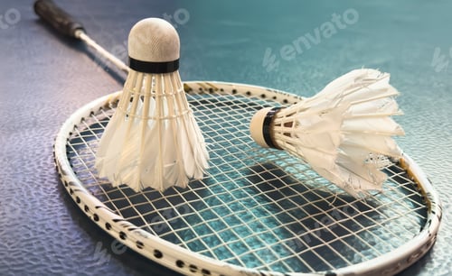 Preview: Broken badminton racket and used white badminton shuttlecocks on purple floor of the court, soft and