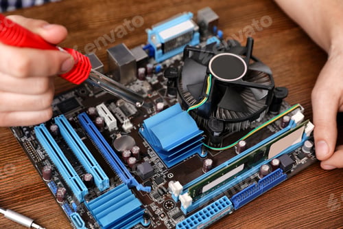 Preview: Male technician repairing motherboard with soldering iron at table, closeup
