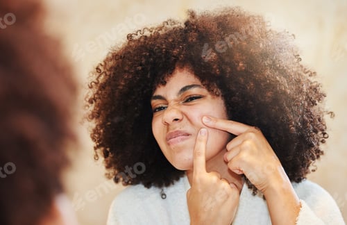 Preview: Shot of a young woman squeezing a pimple while looking in the bathroom mirror
