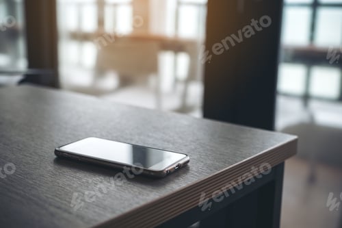 Preview: A single mobile phone on wooden table in the office