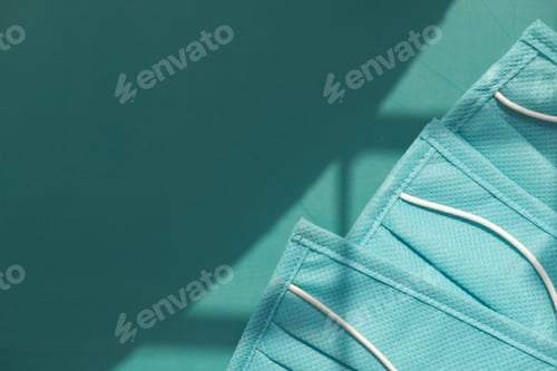Preview: Close up of green surgical masks on color background with copy space