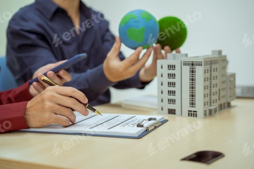 Preview: Two businessmen work at desks office,discussing city clean energy strategies global technology