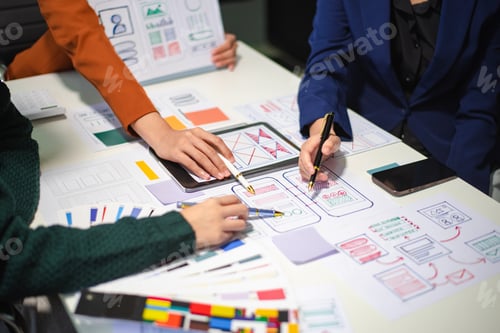 Preview: Close up view of UI developer team brainstorming on their project with laptop, smartphone and
