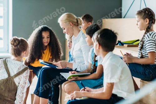 Preview: group of schoolchildren listening to their teacher while sitting on tribune