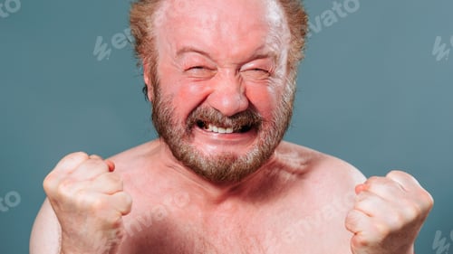 Preview: man aged front view looking at camera clenched teeth holding his hands in front of him in fists