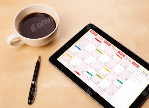 Preview: Workplace With Tablet Pc Showing Calendar And A Cup Of Coffee On A Wooden Work Table Close-Up