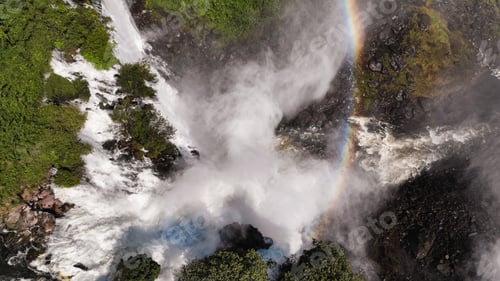 Preview: Kalandula Waterfall cascades in Angola with a vibrant rainbow arching above the lush greenery
