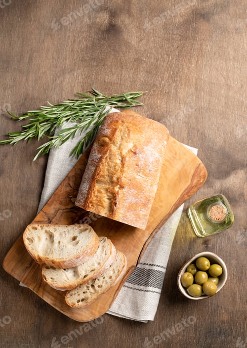 Preview: Fresh italian ciabatta bread cut slices with rosemary and olive oil on wooden background