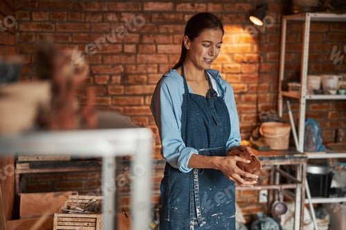 Preview: Happy cheerful caucasian craftswoman working in art studio