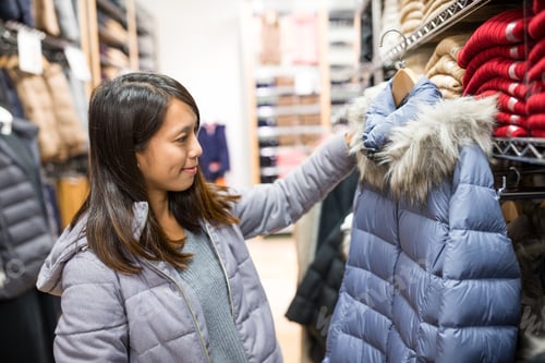 Preview: Asian Woman choosing jacket in boutique