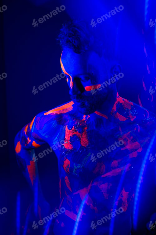 Preview: Portrait of a man with ultraviolet makeup and neon light in cyberpunk style.
