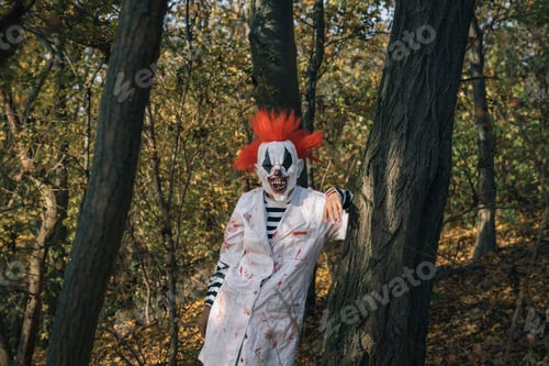 Preview: Halloween scary clown wearing scientist costume hiding in forest