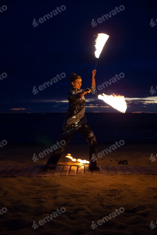 Preview: A girl lights a sparkler on the beach at dusk.