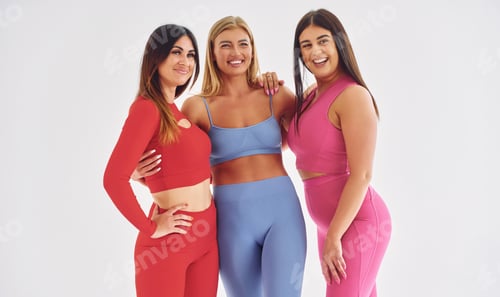 Preview: Standing and smiling. Beautiful women in sportive clothes is indoors in the studio