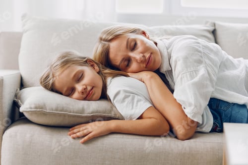 Preview: Mother and daughter peacefully napping on a cozy couch near a sunlit window in a serene living room