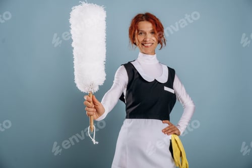 Preview: Ready to clean some dust. Maid in uniform. Woman is in the studio against background