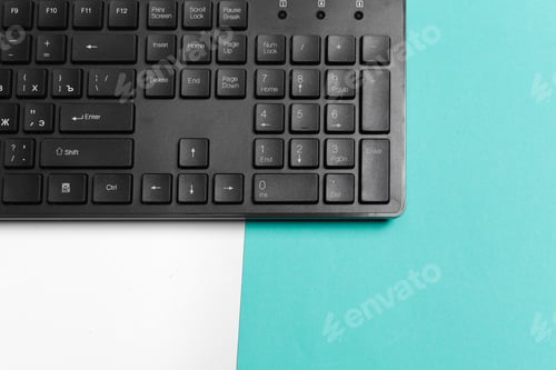 Preview: Computer keyboard on a turquoise paper background