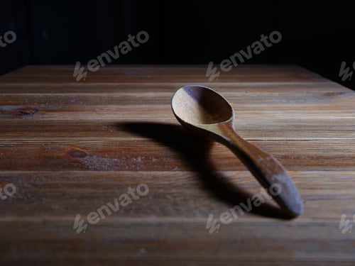 Preview: Old wooden spoon on wooden table.