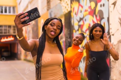 Preview: Fashionable urban style with three black African girls on a city street