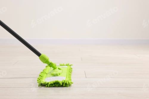 Preview: Microfiber mop on wooden floor indoors, space for text. Cleaning equipment