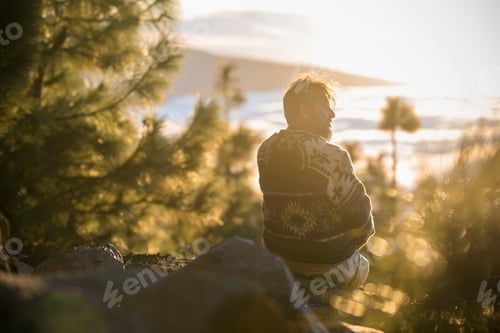 Preview: One man have relax sitting on the cliff looking clouds in background - concept of travel people