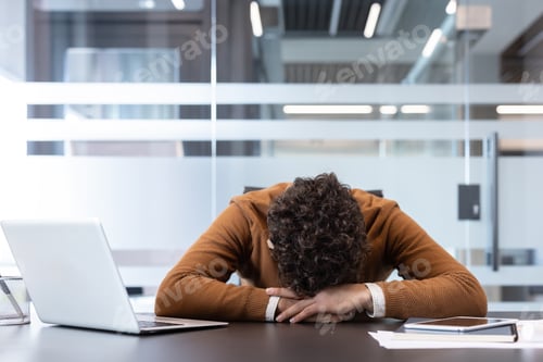 Preview: Burned out man resting head on office desk