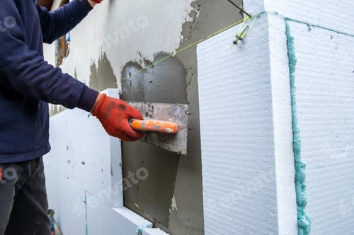 Preview: Construction worker installing styrofoam insulation sheets on house facade wall