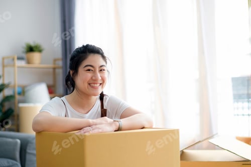 Preview: Happy woman smiling at home during move with boxes
