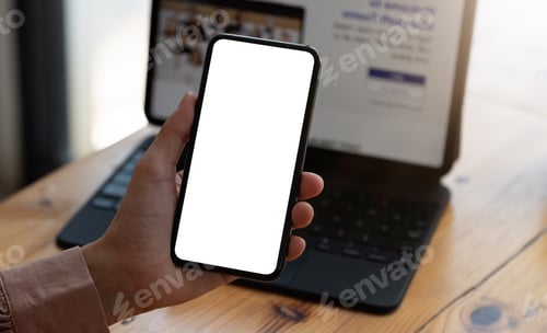 Preview: Top view Woman sitting on work desk and holding blank screen mock up mobile phone.