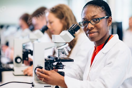 Preview: Young scientist with a bright smile working in a laboratory.