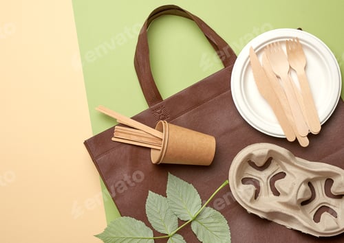 Preview: Disposable paper utensils from brown craft paper and recycled materials on a green background