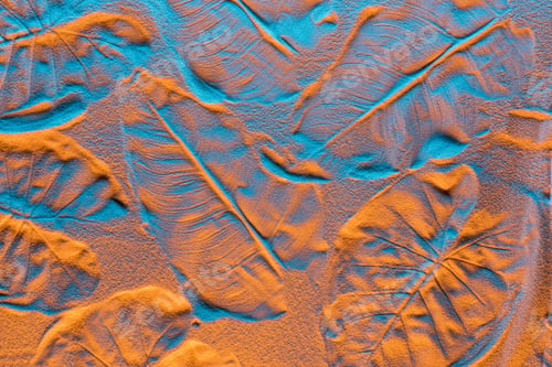 Preview: top view of textured background with leaf prints on sand and color filter