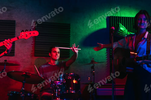 Preview: Musicians In Stage With Colorful Lights Performing In A Live Concert
