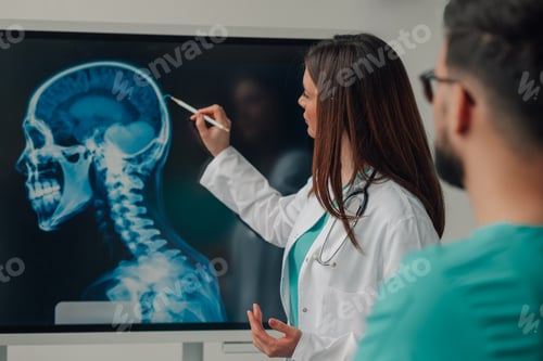 Preview: Medical team examining a head and neck x ray on a digital display