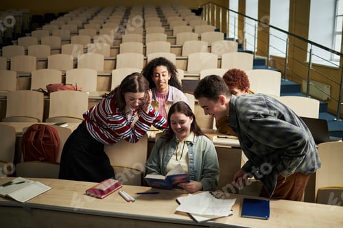 Preview: Multiethnic Young Adult University Students Laughing and Sharing Book in Classroom