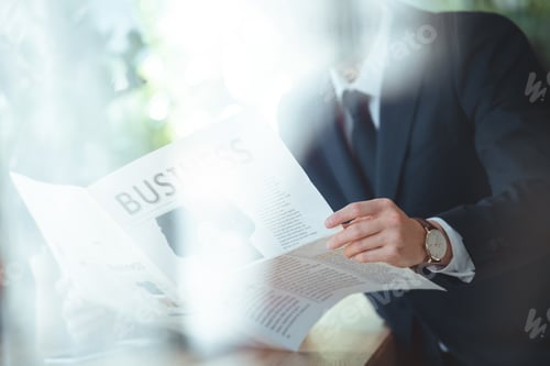 Preview: partial view of businessman with newspaper in cafe