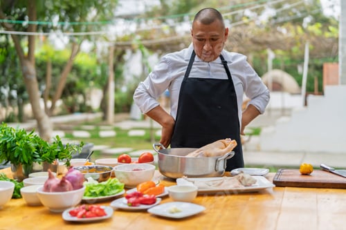Preview: Chef preparing food outdoors with fresh ingredients
