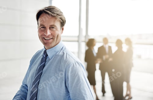 Preview: Cropped portrait of a businessman standing a lobby with his colleagues in the background