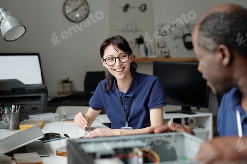 Preview: Young technician talking to colleague