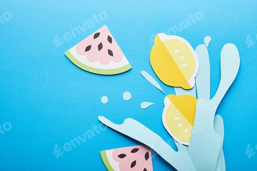 Preview: top view of paper cut water splash with lemons, leaves and watermelons on blue background
